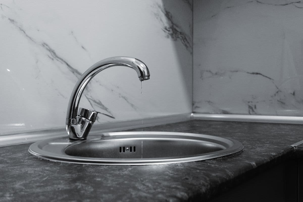 Chrome kitchen tap with a drip of water